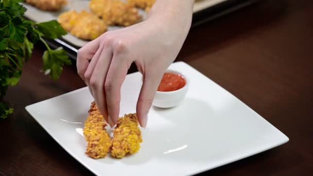 En kvinnlig hand lägga i en skål med Kycklingstrimlor — Stockvideo