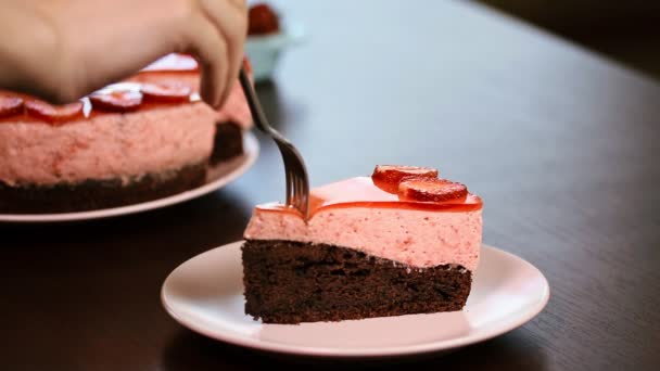 Woman eating chocolate cake with strawberry mousse — Stock Video