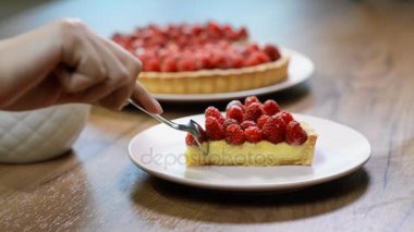 Kesme bir ahududu Tart bir kaşık ile ilk parçası ve bir bıçak, tatlı yeme, aşırı yakın