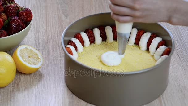 Chef-kok knijpt crème. Handen knijpen opgeklopte Slagroom gebak tas. Aardbei taart maken — Stockvideo