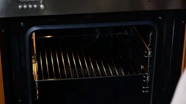 Kadın mutfak closeup fırına hamuru kek için koydum. Pişirme süresi.