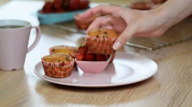 Kız muffins bir tabak koyar