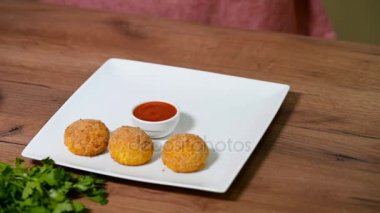 Kadın eli beyaz tabak Arancini pirinç topları koyar