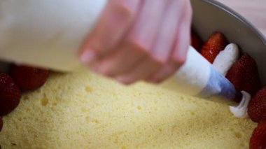 Kremayı hamur işi çanta sıkmak. Çilekli pasta pişirme