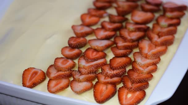 Meisje in de keuken bereiden tiramisu. Versier de tiramisu met aardbeien — Stockvideo