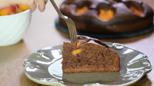 Rebanada de pastel de capa de chocolate con albaricoques. Comer el pastel de chocolate con los albaricoques — Vídeos de Stock