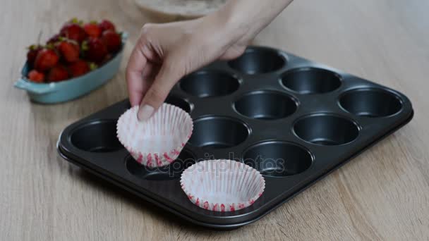 Cozinhar Cupcake, colocar embalagens de cupcake em assadeira — Vídeo de Stock