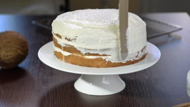 Η διαδικασία της λήψης ένα κέικ. Οι ζαχαροπλάστες εξισώνει Μπισκοτόκρεμα χρησιμοποιώντας σπάτουλα ζαχαροπλαστικής. — Αρχείο Βίντεο