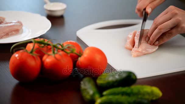 Mujer cortando pechuga de pollo en la mesa — Vídeos de Stock