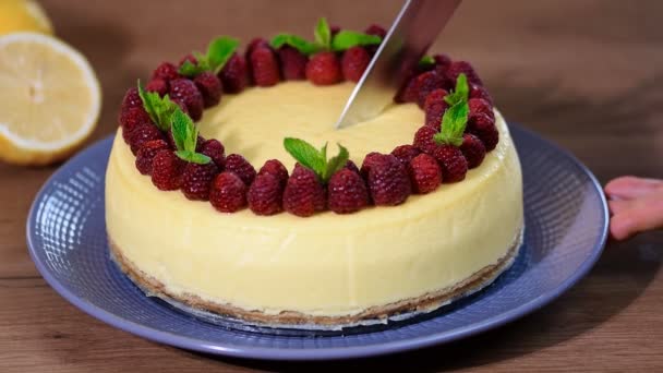 Een vrouw snijd met een mes segment cheesecake New York — Stockvideo