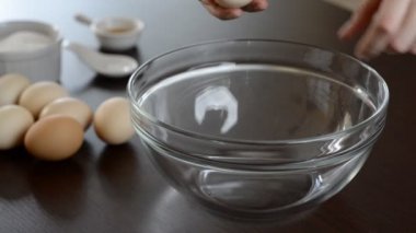 Dişi eller yumurta kırıyor ve sarısını beyazdan ayırıyor..