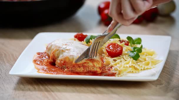 Ιταλικό φαγητό: κοτόπουλο με ντομάτα και ζυμαρικά γκρο πλαν. Το κορίτσι τρώει — Αρχείο Βίντεο