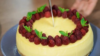 Kadının biri bir bıçak dilim peynirli kek ile New York kesip