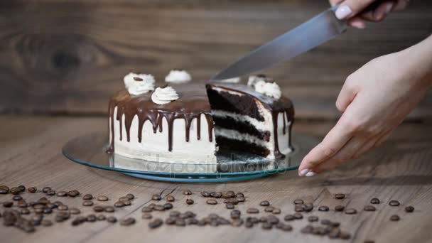 Koch schneidet Schokoladenkuchen. Schokoladenkuchen in Scheiben schneiden. Mann reicht Tortenaufschnitt auf Holztisch. — Stockvideo