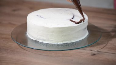 Kadın Şef yemek mutfakta, tatlı bir pasta hazırlama krem çikolata sağanak