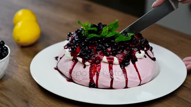 Cortar con un pastel de cuchillo de cocina Pavlova. Merengue pastel pavlova con crema batida — Vídeos de Stock