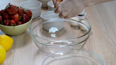 Dişi eller yumurta kırıyor ve sarısını beyazdan ayırıyor..