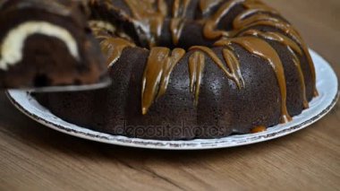 Kız çikolatalı kek krem peynir ile bir parça kesip bir plaka yakın çekim vuruşta yerleştirir