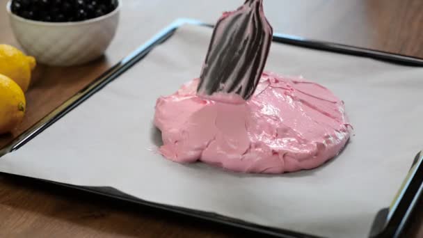 Uitvalsbasis voor pavlova (meringue gebaseerd dessert). Versieren wervelingen worden toegevoegd aan de afgevlakte romige eiwit en suiker mix op een bakplaat, klaar voor de oven. — Stockvideo