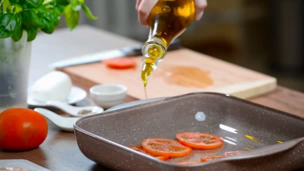 Gieten olijfolie over de tomaat. Koken van de kip Caprese — Stockvideo