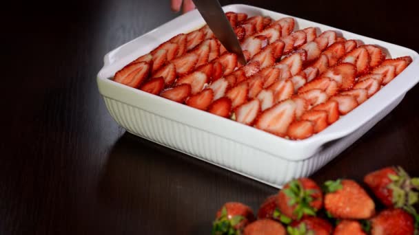 Una donna taglia un tiramisù di fragole con un coltello. Dessert tiramisù alla fragola . — Video Stock