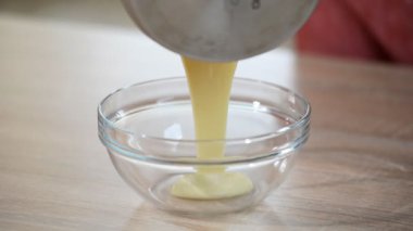 Sıcak krem Creme brulee tatlısı için bir muhallebi karışımı oluşturmak için kase karıştırma içine dökülür varlık.