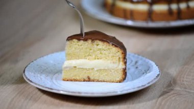 Ev yapımı boston kremalı pasta, krema ile doldurulmuş ve çikolata ile buzlu pasta. Boston kremalı pasta yiyen kız