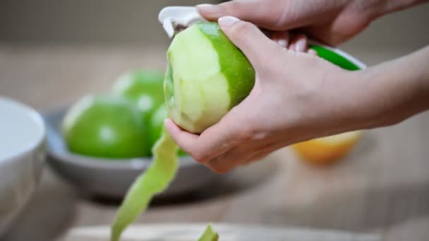 Lidská ruka čistí zelené jablko jako spirála — Stock video
