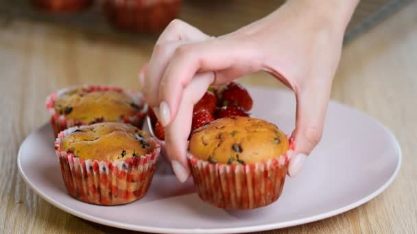 Κορίτσι βάζει ένα πιάτο muffins — Αρχείο Βίντεο