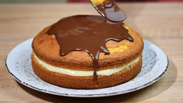 Boston cream pie with chocolate glazing. Pouring chocolate ganache on a Boston cream pie — Stock Video