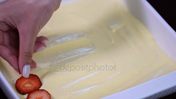 Κορίτσι στην κουζίνα προετοιμασία τιραμισού. Διακοσμήσετε το Τιραμισού με φράουλες — Αρχείο Βίντεο