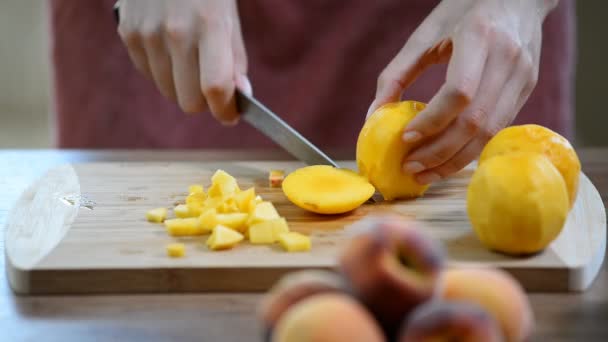 Girl peach slices on a wooden Board — Stock Video