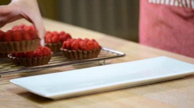 Beyaz tabağa koy ahududu ile lezzetli çikolatalı tart.