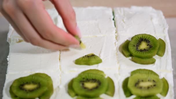 Frauen Hand dekorierte Kuchen Kiwi — Stockvideo