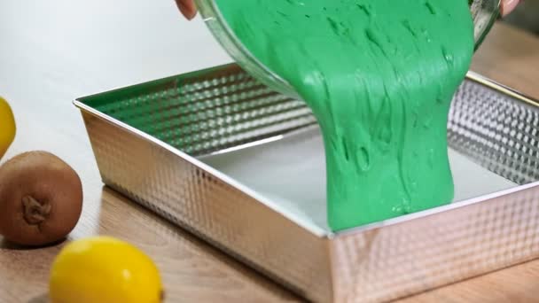 Pouring green cake batter into cake mold — Stock Video