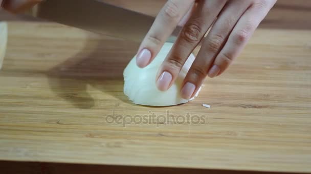 Tangan koki dengan pisau memotong bawang di papan kayu. — Stok Video