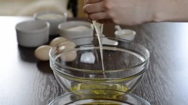 Taze organik yumurta kasenin içine düşüyor. Malzemeler, sarısı protein ayıran pişirme.