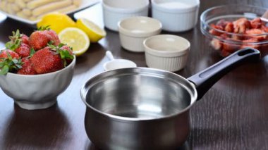 Taze çilek bir tencereye koyarak