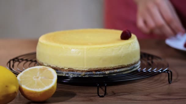 一个女人在厨房里装饰着覆盆子乳酪蛋糕纽约 香草纽约芝士蛋糕与覆盆子 — 图库视频影像