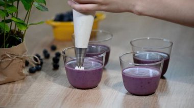 Panna cotta krem şanti ile süsleyin. Krema ile bir hamur işi çanta sıkmak