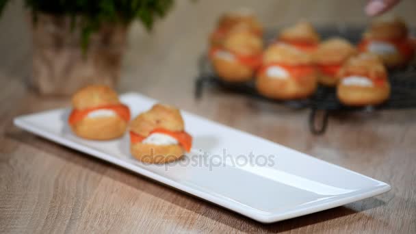 Vrouwelijke Handen Zetten Profiterollen Met Zalm Een Witte Plaat — Stockvideo