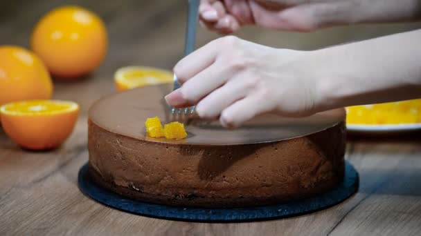 女性手工装饰巧克力慕斯蛋糕与橙色段 — 图库视频影像