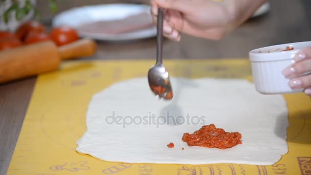 Шеф-повар добавляет томатный соус на тесто для пиццы — стоковое видео
