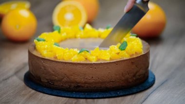 Bir kadın çikolata turuncu mousse kek bir dilim keser