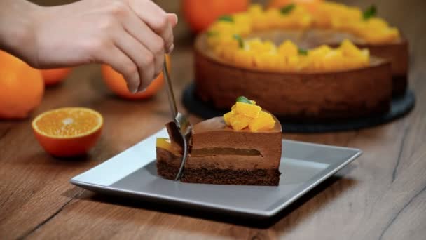 チョコレート オレンジのムースのケーキの部分を食べる — ストック動画