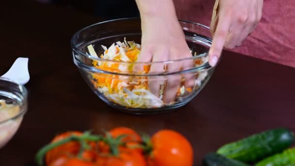 厨房里的一个女人把卷心菜和胡萝卜混在一起 白菜沙拉用红萝卜 在白色碗 — 图库视频影像