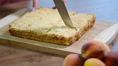 Ev yapımı şeftali turtası. Kız mutfakta şeftali pasta kesme