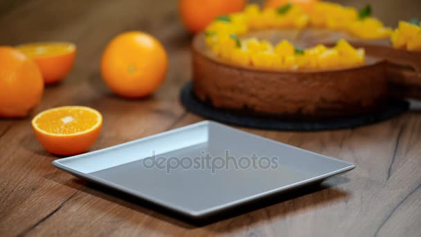 Stuk oranje chocolademousse taart op een bord zetten — Stockvideo