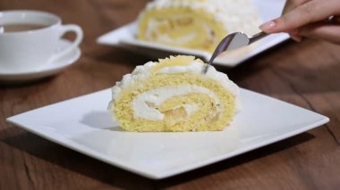Bir kadın bir parça tatlı ananas rulo pasta yiyor