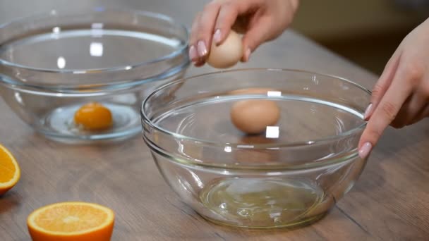 女性の手は卵を砕き 黄身を白から分離 — ストック動画